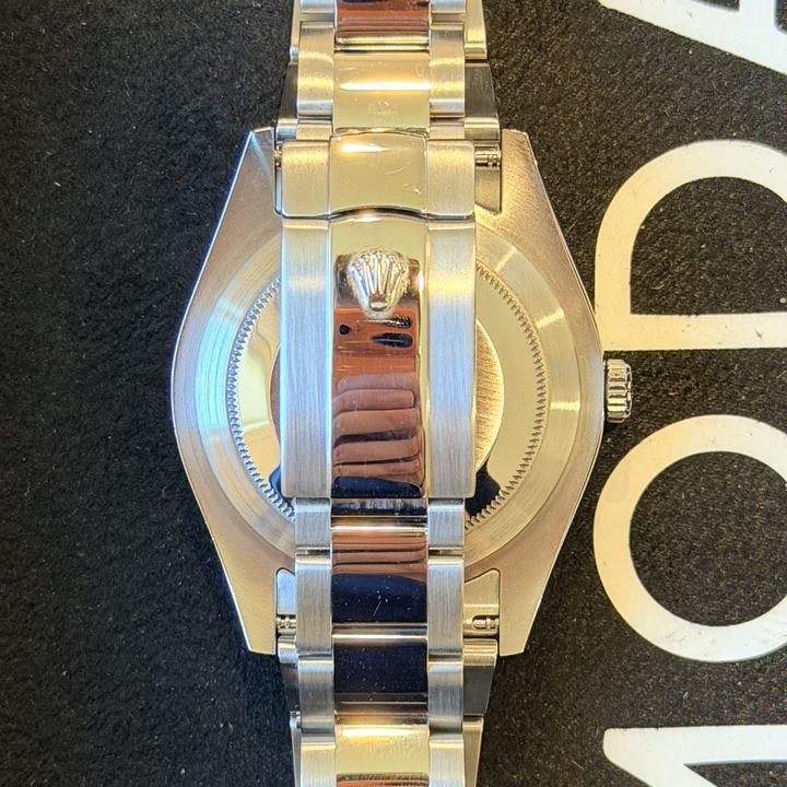 Back of a steel Rolex on an Oyster bracelet, three links across, on a black MODA Watches pad